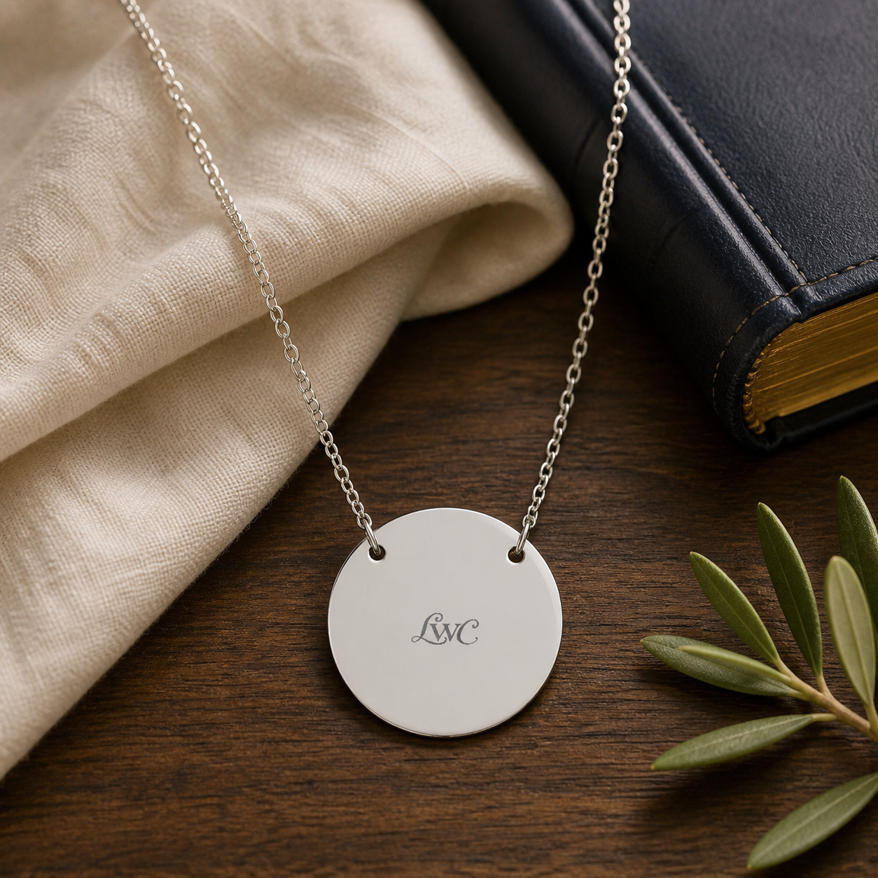 LWC Signature Circle Necklace shown on walnut, linen, and a navy Bible.