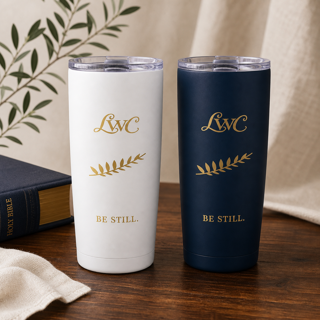 LWC white and navy Be Still tumblers on a premium Bible and walnut table.